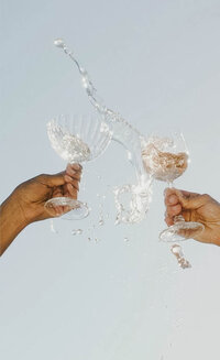 Vacation toast with friends against a bright, sunny sky.