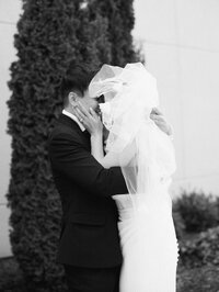 Couple shares candid kiss beneath veil, captured by wedding photographer Cleveland Ohio