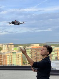 A photographer launching a drone into the sky
