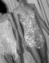 blurry black and white image of two models wearing sparkly wedding dress minis