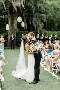 Stunning First kiss photo in front of the beautiful oak tree at Wrightsville Manor in Wrightsville Beach NC.