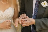 Close up of bride's grandfather looking at his late wife's ring now on his granddaughter's hand—an emotional wedding moment in Estes Park.