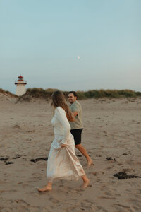 couple walking on beach for lifestyle couples session in pei