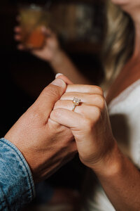 Black and white close-up of mom zipping brides wedding dress an intimate wedding moment