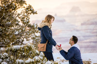 Couple celebrating their engagement with a joyful kiss, with the Grand Canyon’s expansive horizon in the background
