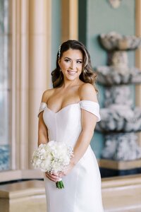 Woman in white dress with white flowers in hand