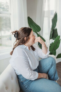 Woman relaxing on couch in brightly lit space
