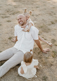 daughters climbing on dad