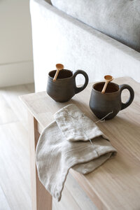 two pottery mugs with wooden mixing spoons in a palm springs living room