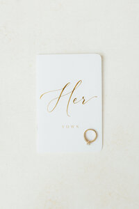 The bride's vow book with the bride's engagement ring sitting on top of it.