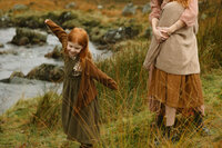 girl plays by stream in scotland 
