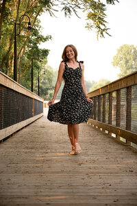 Senior Girl twirling in dress on Eaton Rapids bridge