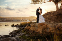 Bride and groom kiss on a ledge overlooking the waterfront on the Bay Area Ridge Trail, photo by wedding photographer sacramento ca philippe studio pro