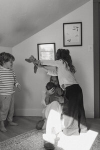  A tender motherhood moment of a mom holding her newborn, photographed in soft, natural light in rural Maine.