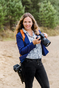 Juliette Fotografie in actie, kijkend in de camera met een camera in haar hand