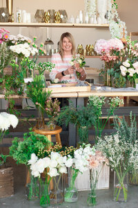 Dena in Larson Floral Co studio designing a small toss bouquet