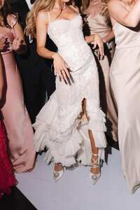 Close-up of a bride's flowing wedding dress swirling as she dances during her wedding reception in La Jolla, San Diego, capturing movement and elegance with direct flash.