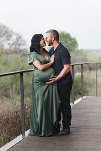 A San Antonio senior smiles and tucks her hair behind her ear while looking off to her side during senior pictures with photographer Cassey Golden.