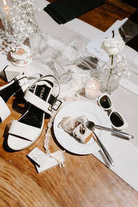 Photo of wedding shoes, wedding cake, sunglasses and wedding paraphernalia taken by Top rated wedding photographer Portland Maine 