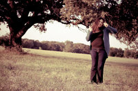 San Antonio Photographer Irene Castillo dancing under a tree in a field