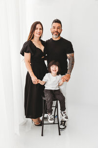 family of 3 posing for classic studio family session in phoenix