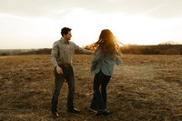 man twirling his fiance in open field in Wisconsin
