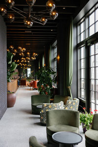 Architecture photo of Book Tower Detroit. Green chairs and moody brown decor.