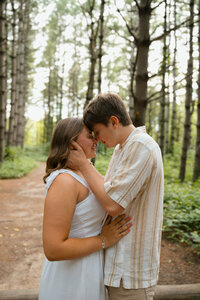 couple lies in field during engagement photoshoot in missouri