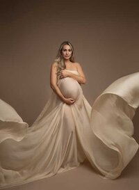 Mom dressed in a flowy drape taking a maternity portrait in Atlanta photo studio.