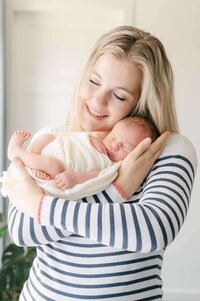 moeder met newborn baby jongen in doek gewikkeld in haar armen