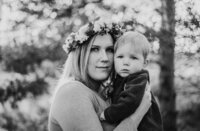 black and white photograph  of a mother wearing a flower crown holding her toddler son
