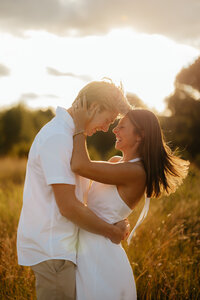 man and woman kissing in front of rock formation
