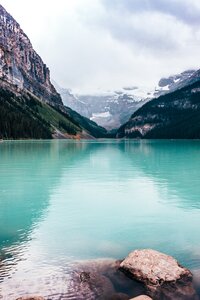 Turquoise blue  water with large mountains scaling each side of the river