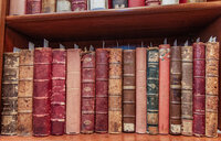 Stacks of old books on a shelf