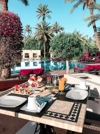 Breakfast on a table in a resort next to a pool