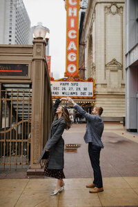 A couple dancing by the Chicago theater sign