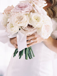 Elegant bridal bouquet of blush and ivory roses tied with a silk ribbon — refined wedding detail captured by Asia Pimentel Photography.