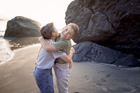 twin boys hugging and playing on the beach