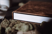 A closed wedding album book rests on a table