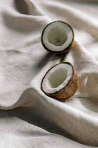 Half of a coconut on a silky beige fabric