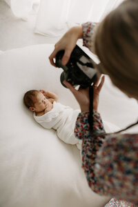 lucy jane, a professional christchurch newborn photographer photographing a baby during a photoshoot in her studio