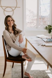 Website copywriter Erika Fitzgerald sitting at her desk with a laptop, writing website copy for creative small businesses