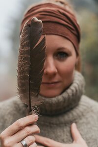 Isabell mit Vogelfeder vor ihrem Gesicht