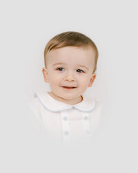 Young boy smiles for the camera during heirloom portrait session with Worth Capturing