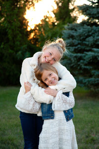 Two sisters hugging and smiling.