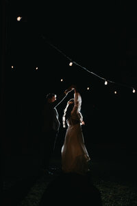 silhouette of bride and groom dancing in the night under the stars