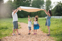 Family jumping under blanket