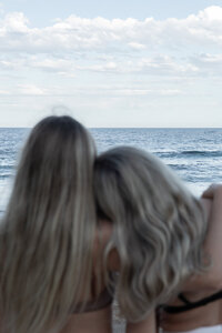 Two women watching waves crash