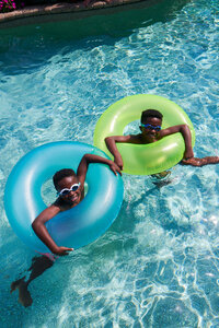 Two kids in a rubber floater, enjoying a carefree and playful time in the water