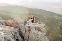 girl sitting on top of rocks for her senior photos
